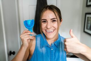 woman holding dental impression for custom sports mouth guard