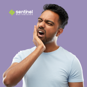 Person clutching jaw in pain, indicating teeth grinding